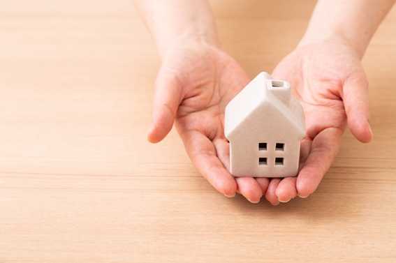 家の模型を手に載せている様子