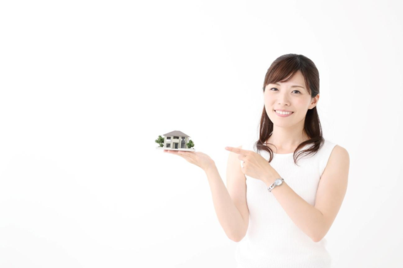 女性が手のひらに住宅の模型を乗せ、指を指している